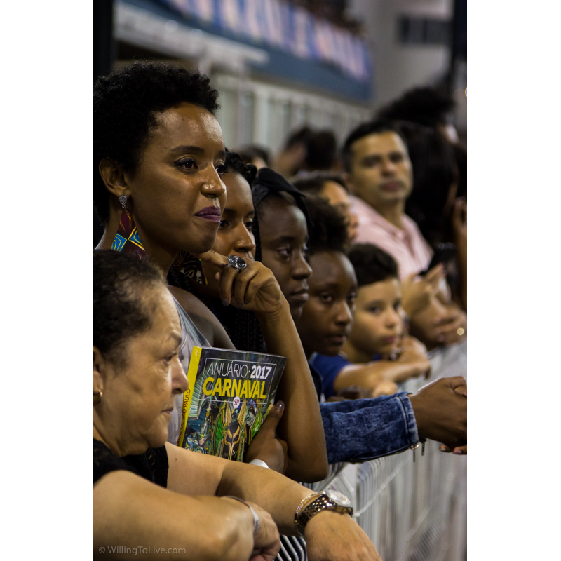 A moça tem até um livro do carnaval do ano passado. Deve gostar pouco dos desfiles, né? hehehe Com esse olhar ainda... | ISO 800; 168mm equiv.; f/4; 1/160s