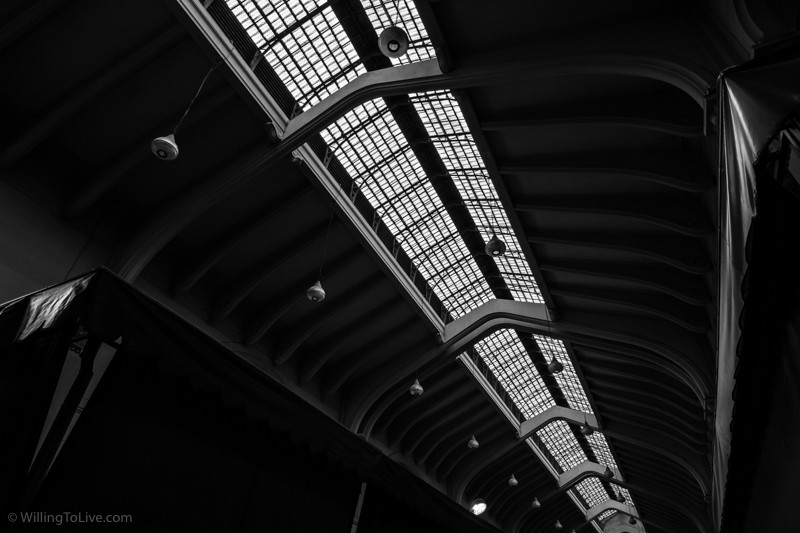 Luz e arquitetura local. Como você deve imaginar vendo essa fotografia, o horário do dia influencia no tipo de luz no Mercadão. Ao redor do meio-dia, a luz do sol entra de forma mais intensa pelo teto, nos outros horários ela fica mais suave e funciona melhor como uma luz de preenchimento | ISO 100; 21mm equiv.; f/11; composição com tempos de exposição diferentes